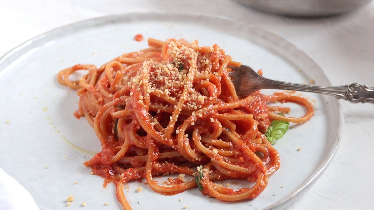 Vegan parmesan on top of spaghetti al pomodoro