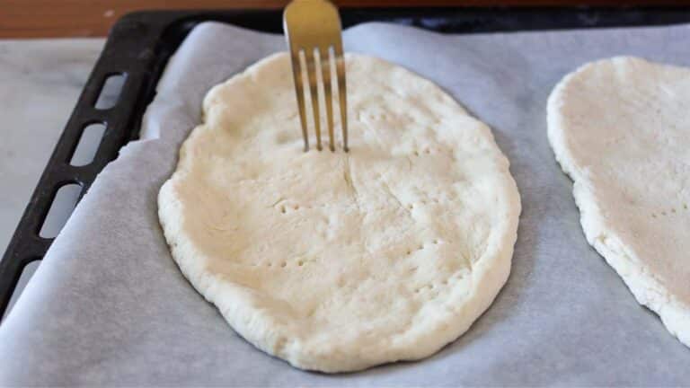 piercing the flatbread with a fork