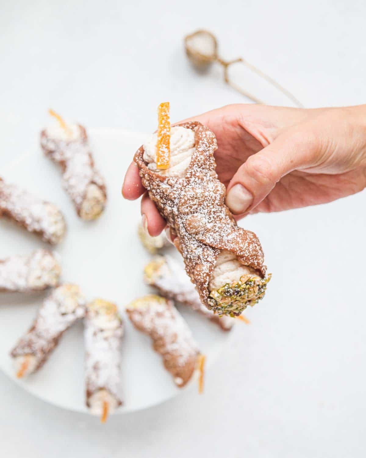 Female hand holding a freshly made cannolo siciliano