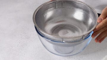 preparing a sieve on top of a large bowl