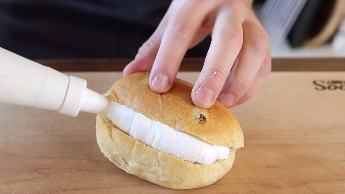 filling the vegan bun with whipped cream