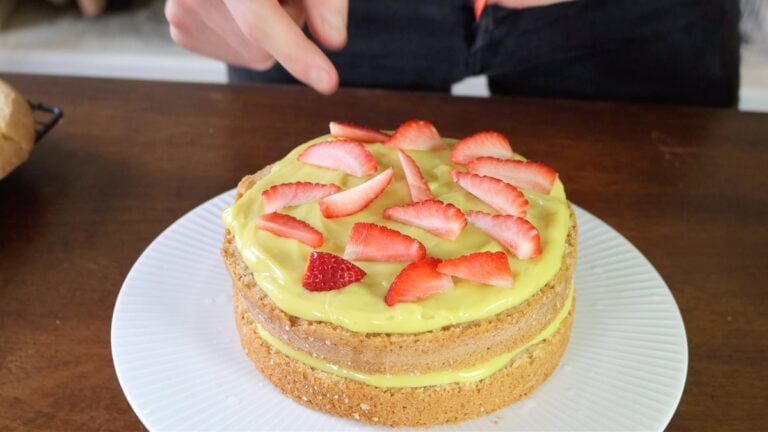 covering the cake with pastry cream and strawberries