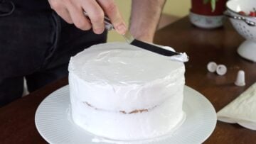 Covering the vegan vanilla cake with whipped cream