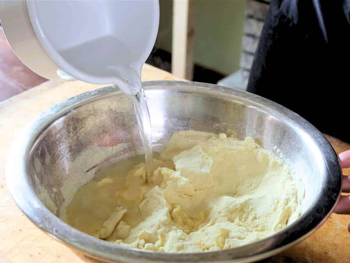 Step 1 Mixing semolina flour and water in a bowl for trofie pasta dough.