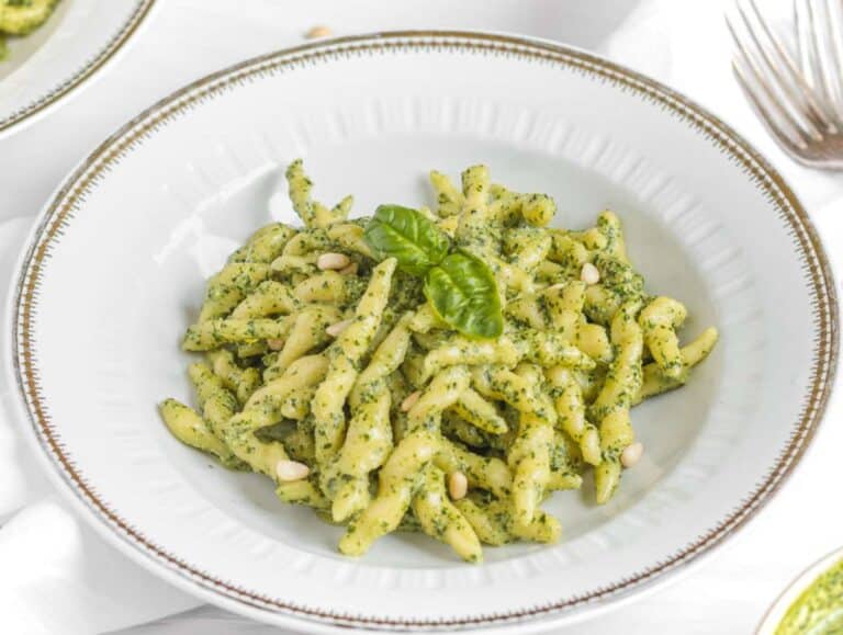 Step 5 Cooked trofie pasta tossed in basil pesto and served in a gold-rimmed pasta plate