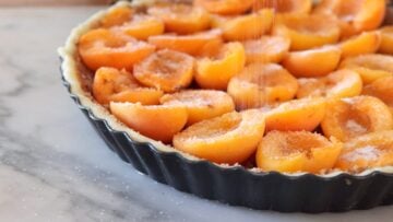 adding some sugar on top of the apricot tart