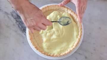 filling the fruit tart crust with custard