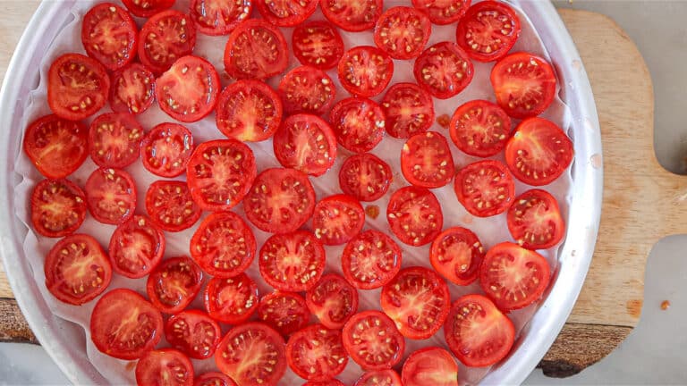 arranging cut tomatoes on baking tray
