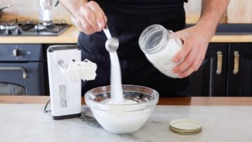 adding sugar to the whipped cream
