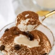 spoon eating through a glass with coffee mousse