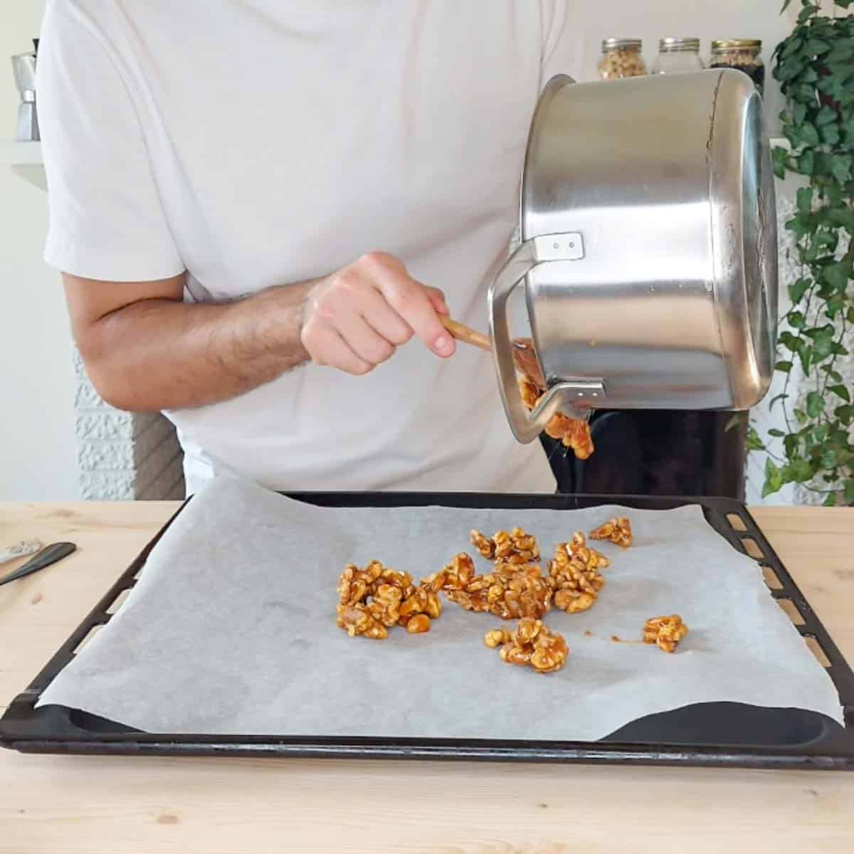 transferring candied walnuts onto parchment paper