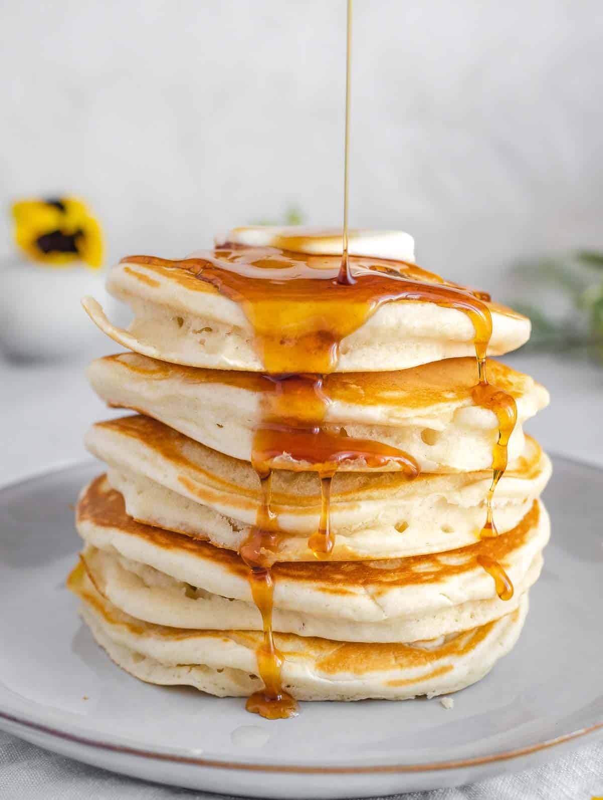 vegan pancakes dripping with maple syrup