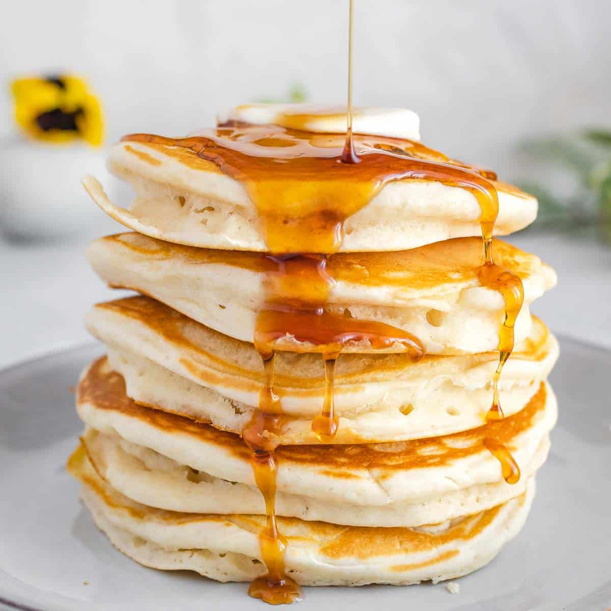 vegan pancakes with maple syrup dripping all over