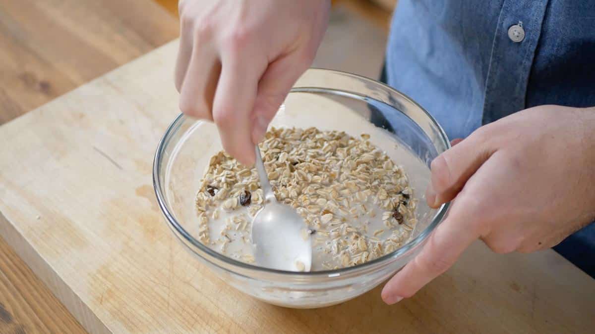 mixing oats milk and raisins in a bowl