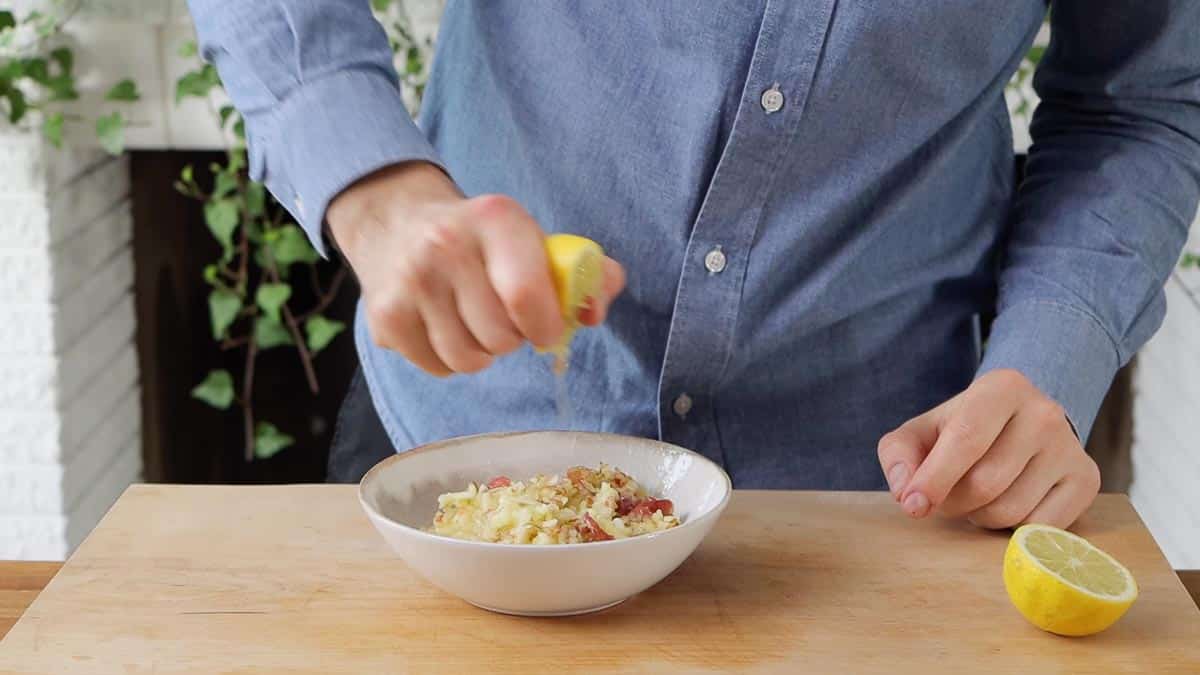 squeezing a lemon over the grated apple