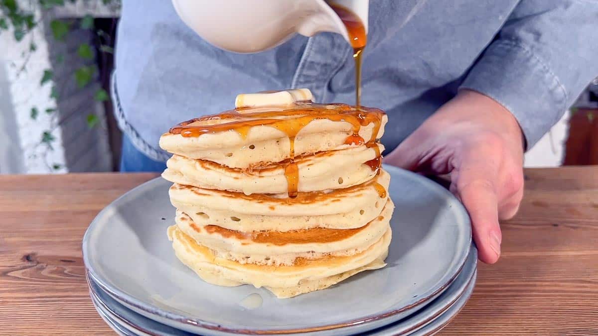 pouring 100% maple syrup on the pancakes