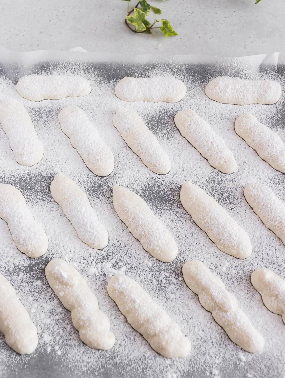 vegan ladyfingers on a baking tray and covered in sugar
