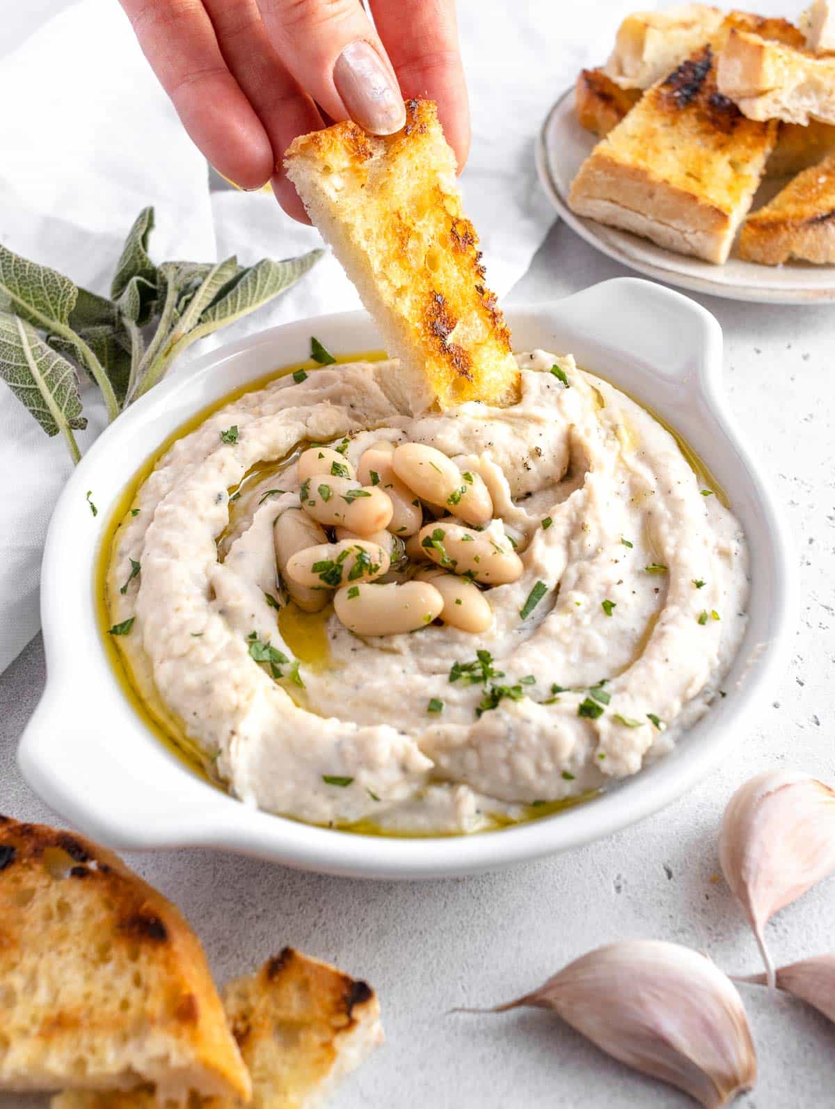 Louise che intinge un pezzo di pane tostato nella crema di fagioli