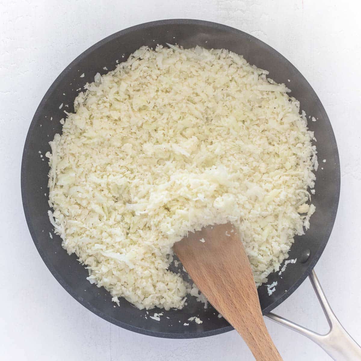 cauliflower rice cooking in a pan