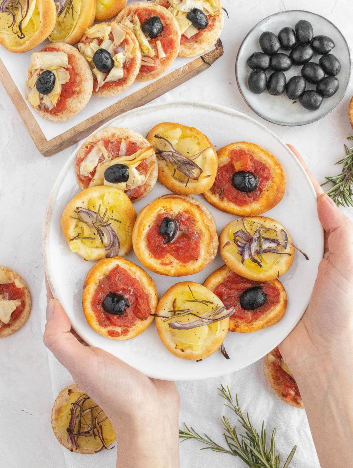 Louise holding a plate with mini pizzas