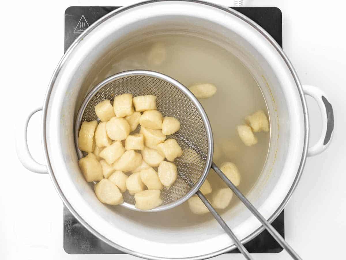 scooping out the gnocchi from the water