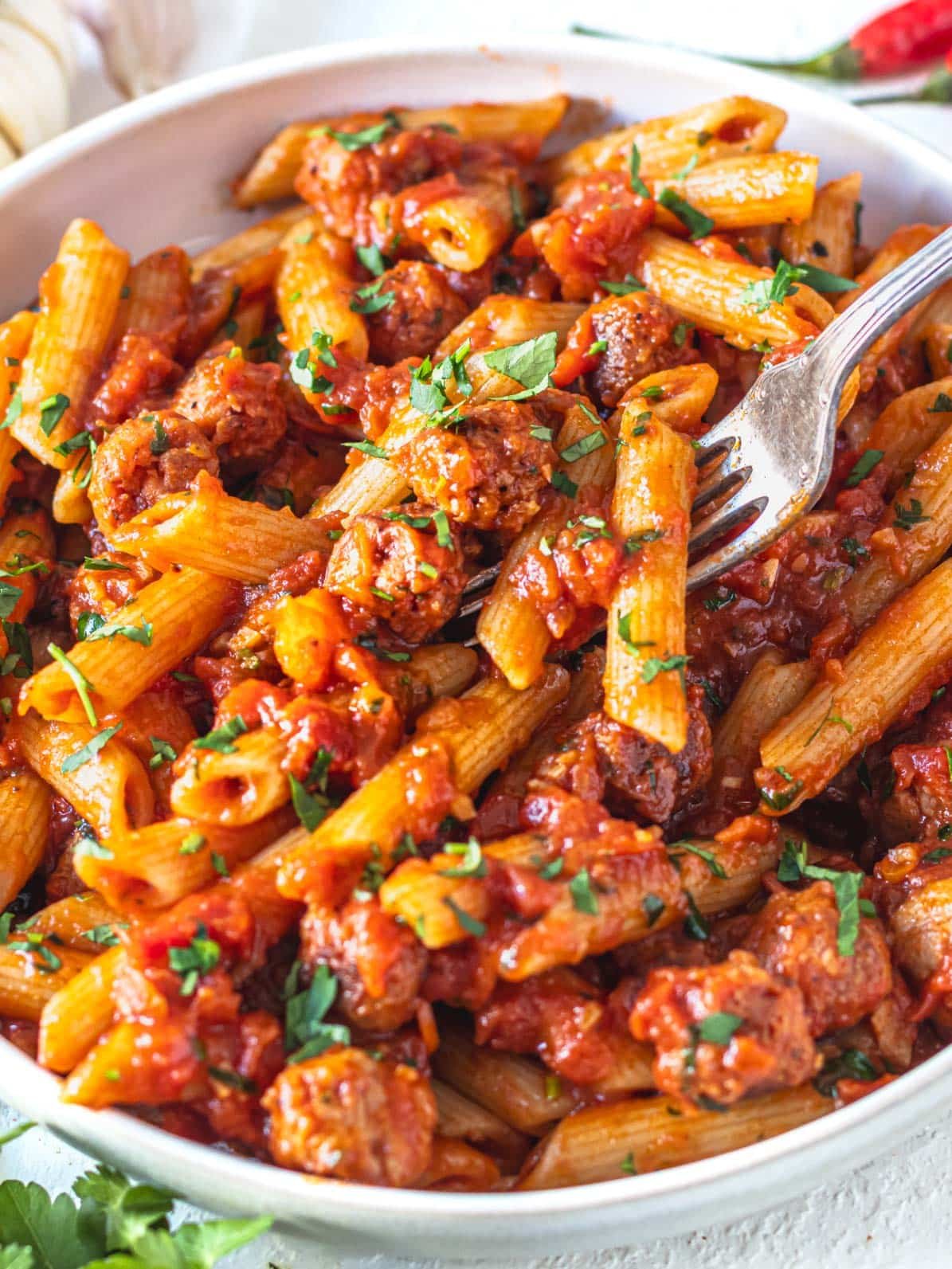 Penne arrabbiata with sausage and a silver fork