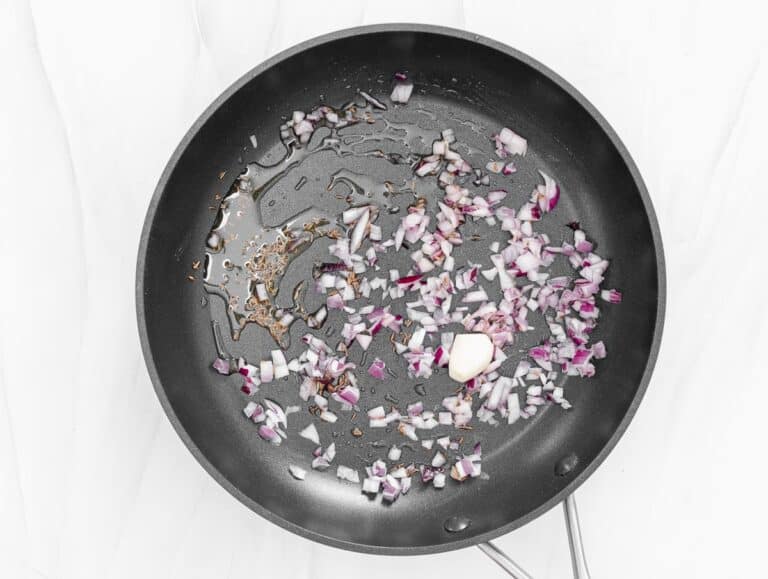 chopped onions in a pan with oil and garlic
