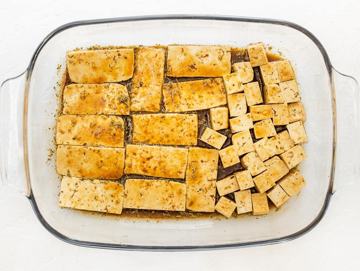 cubes and slabs of tofu in a dish coated in marinade