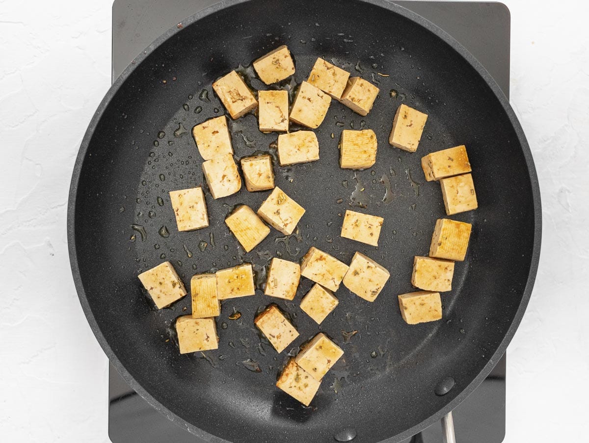 marinated tofu cooking on a non-stick pan