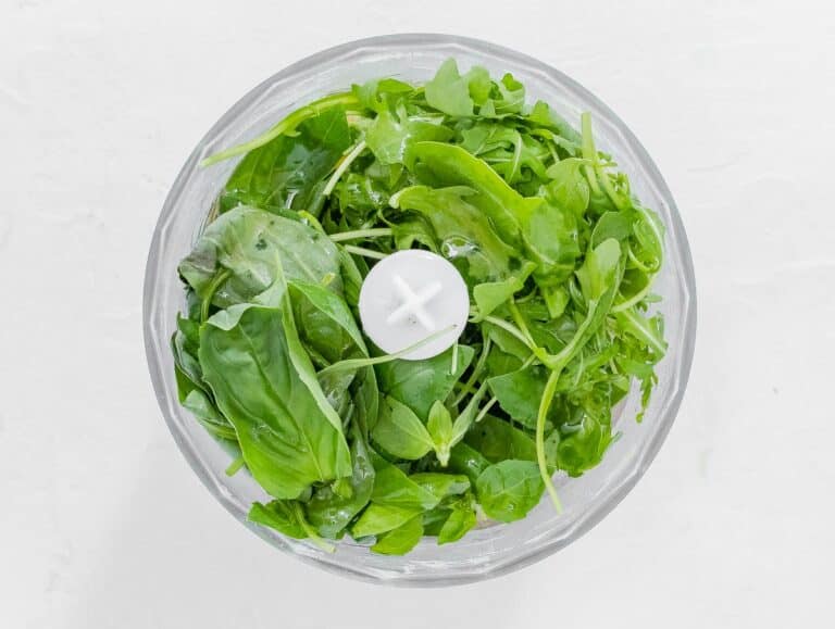 arugula and basil leaves in food processor