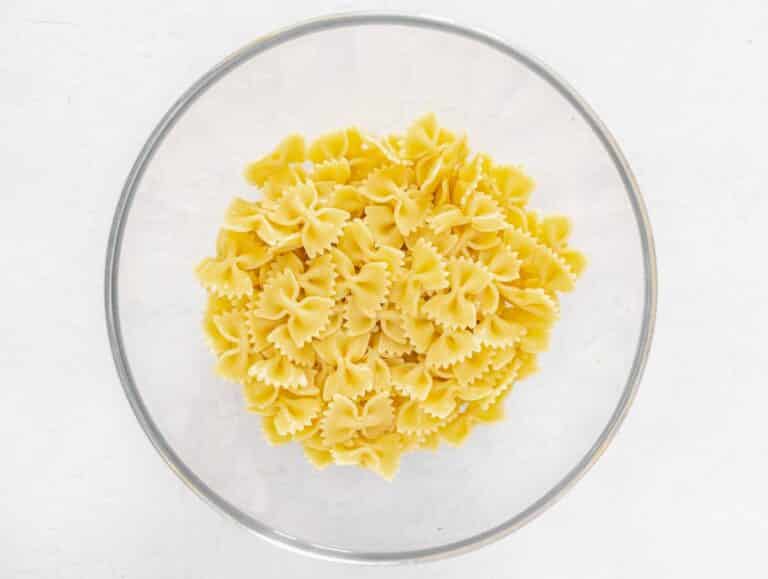 bow ties pasta in mixing bowl with a drop of oil