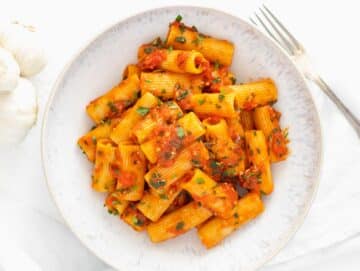rigatoni arrabbiata in a plate with fresh parsley on top