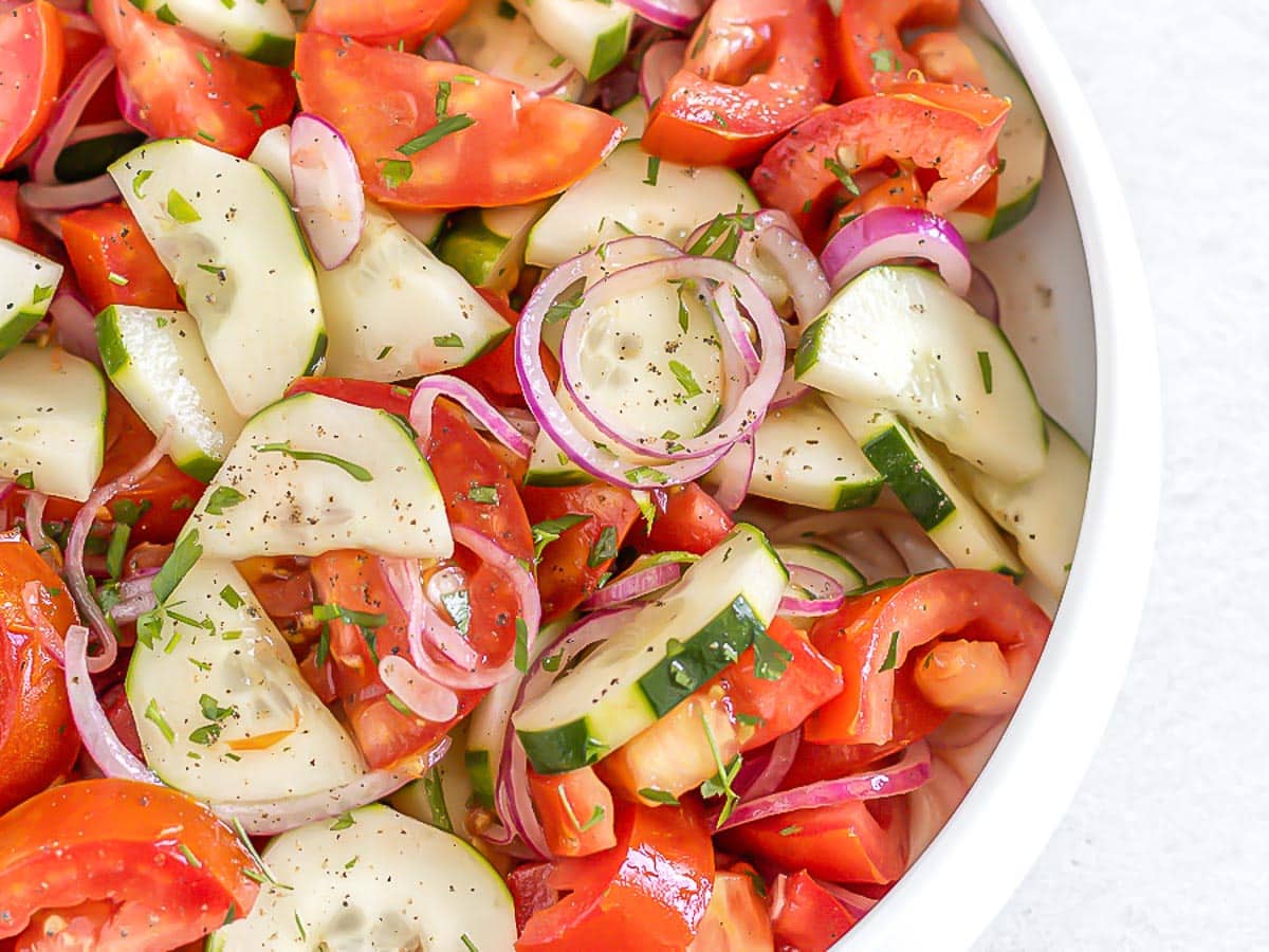 tomato cucumber salad in a white bowl