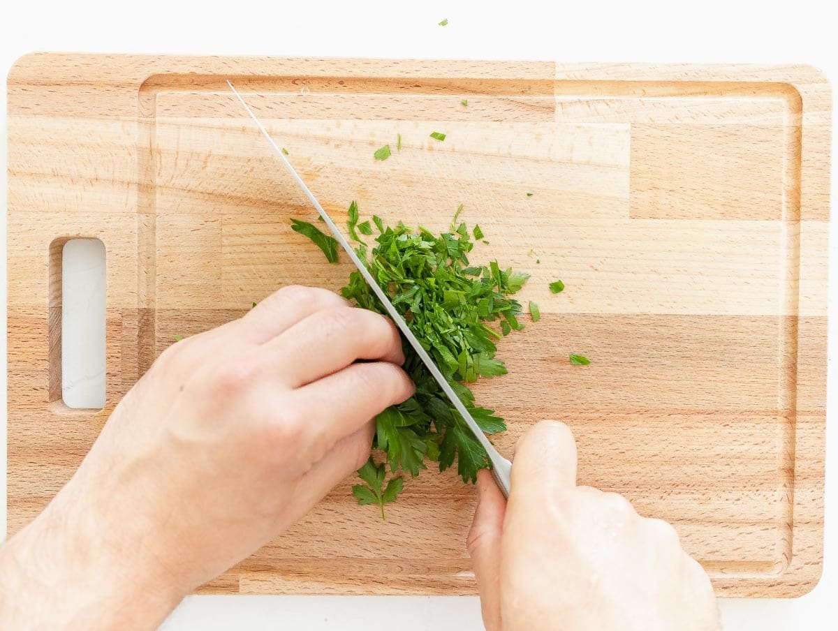 chopping the parsley on cutting board