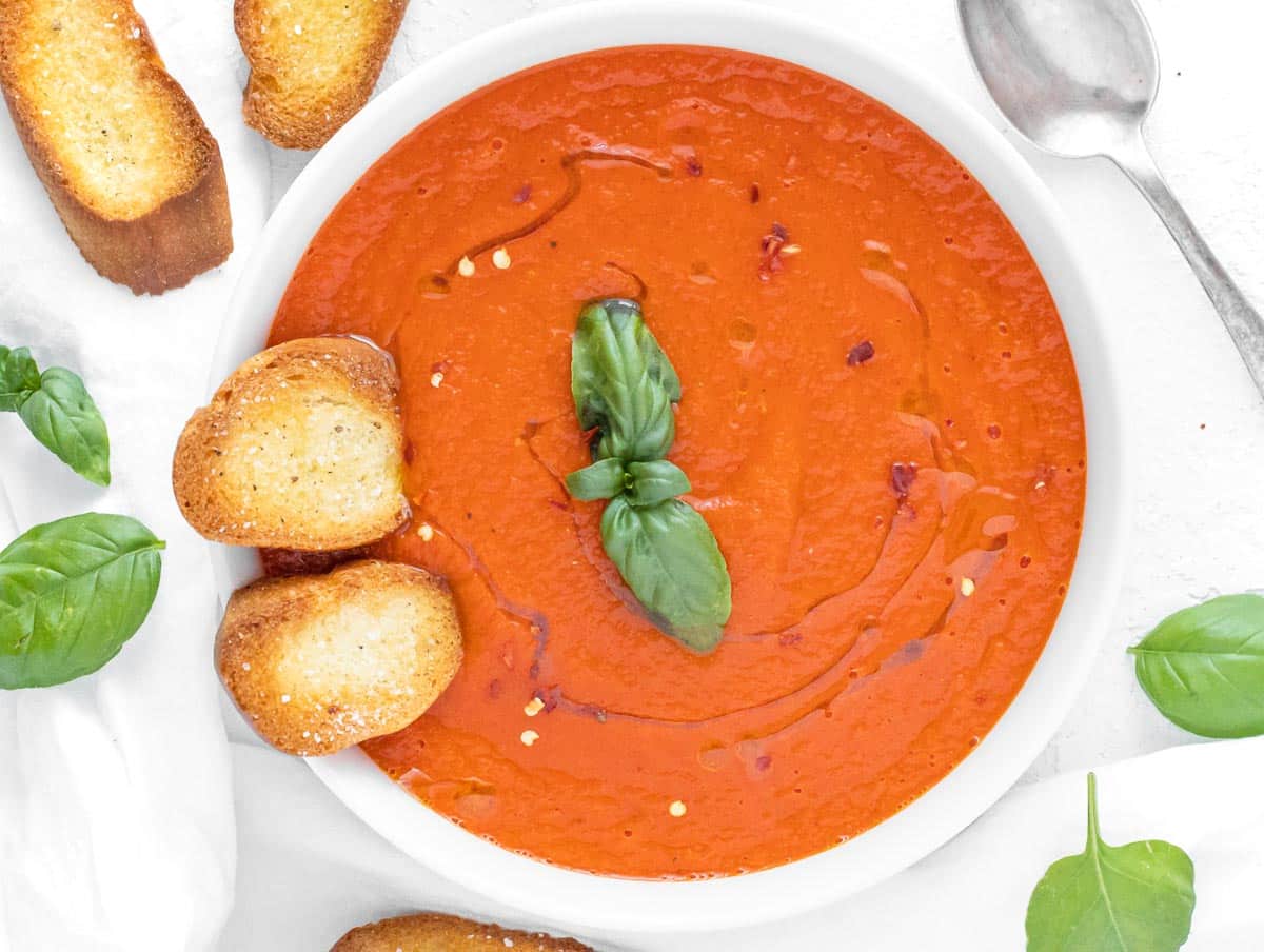 Crostini and tomato soup in a white bowl