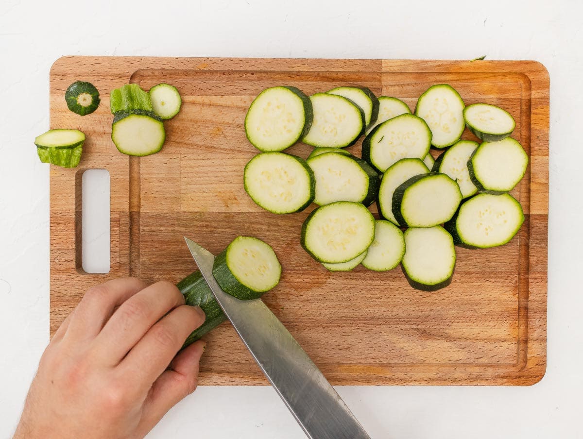 cutting round zucchini slices with a chef's knife