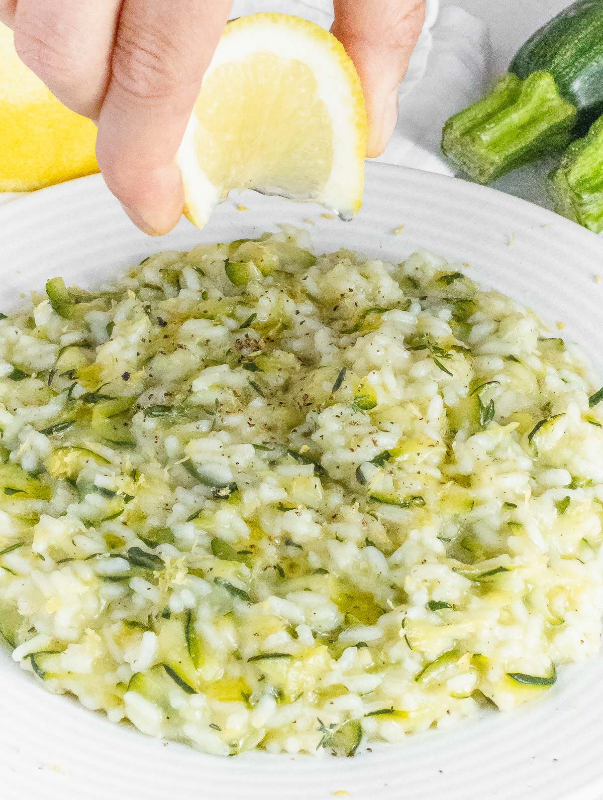 squeezing a touch of lemon of zucchini risotto