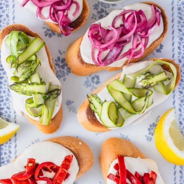 crostini recipe with colorful toppings and lemon wedges