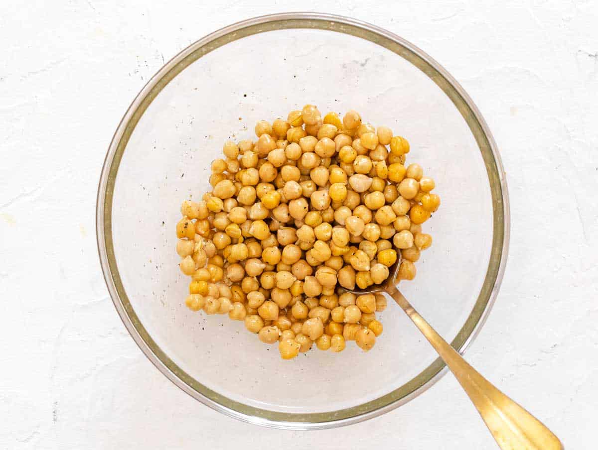 seasoning the chickpeas with olive oil, salt, and pepper