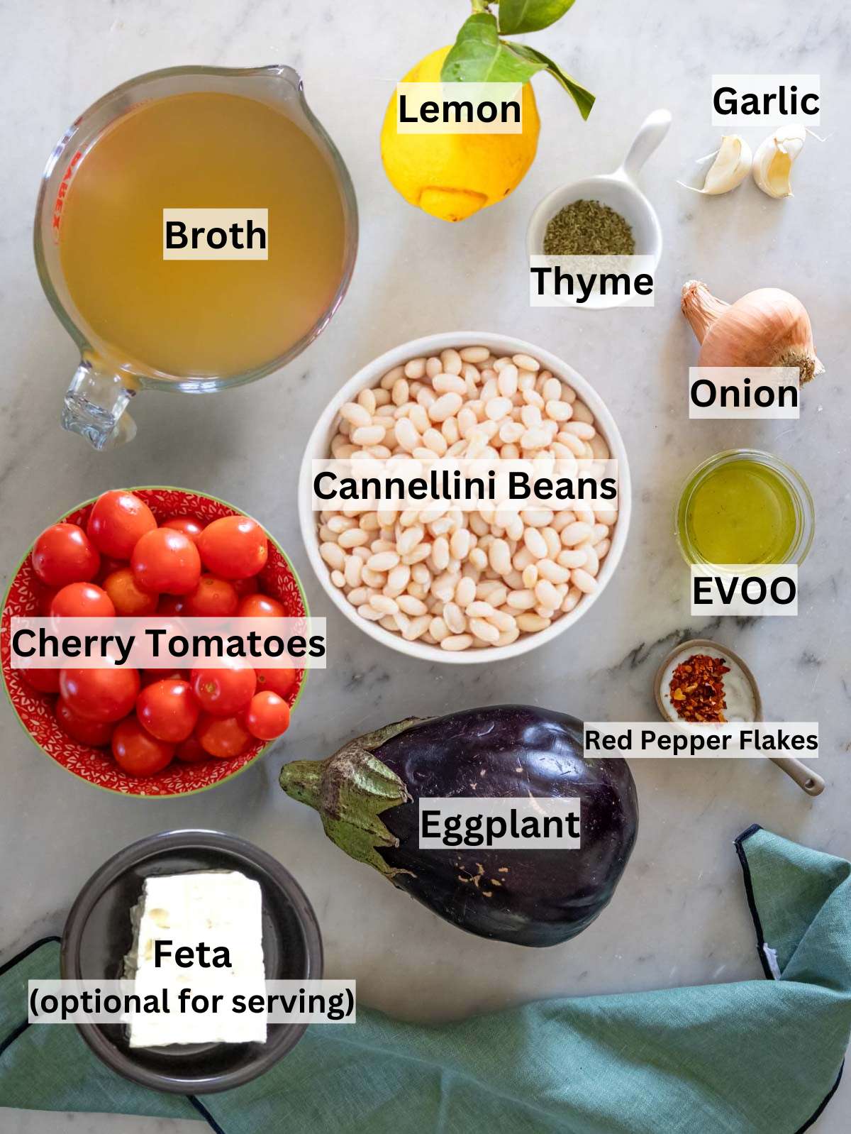 Ingredients picture – Fresh eggplants cherry tomatoes beans garlic and herbs arranged for Mediterranean eggplant soup.