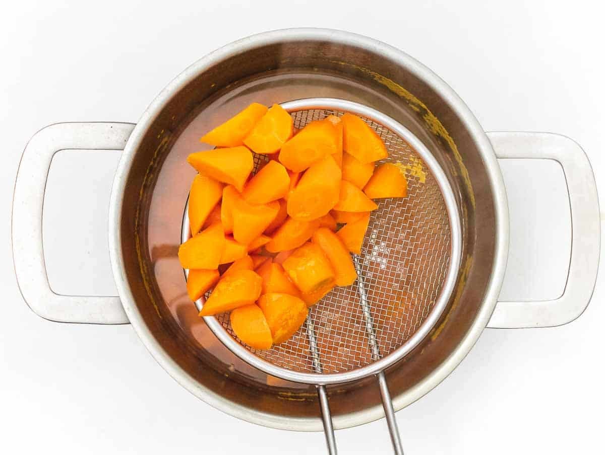 draining boiled carrots