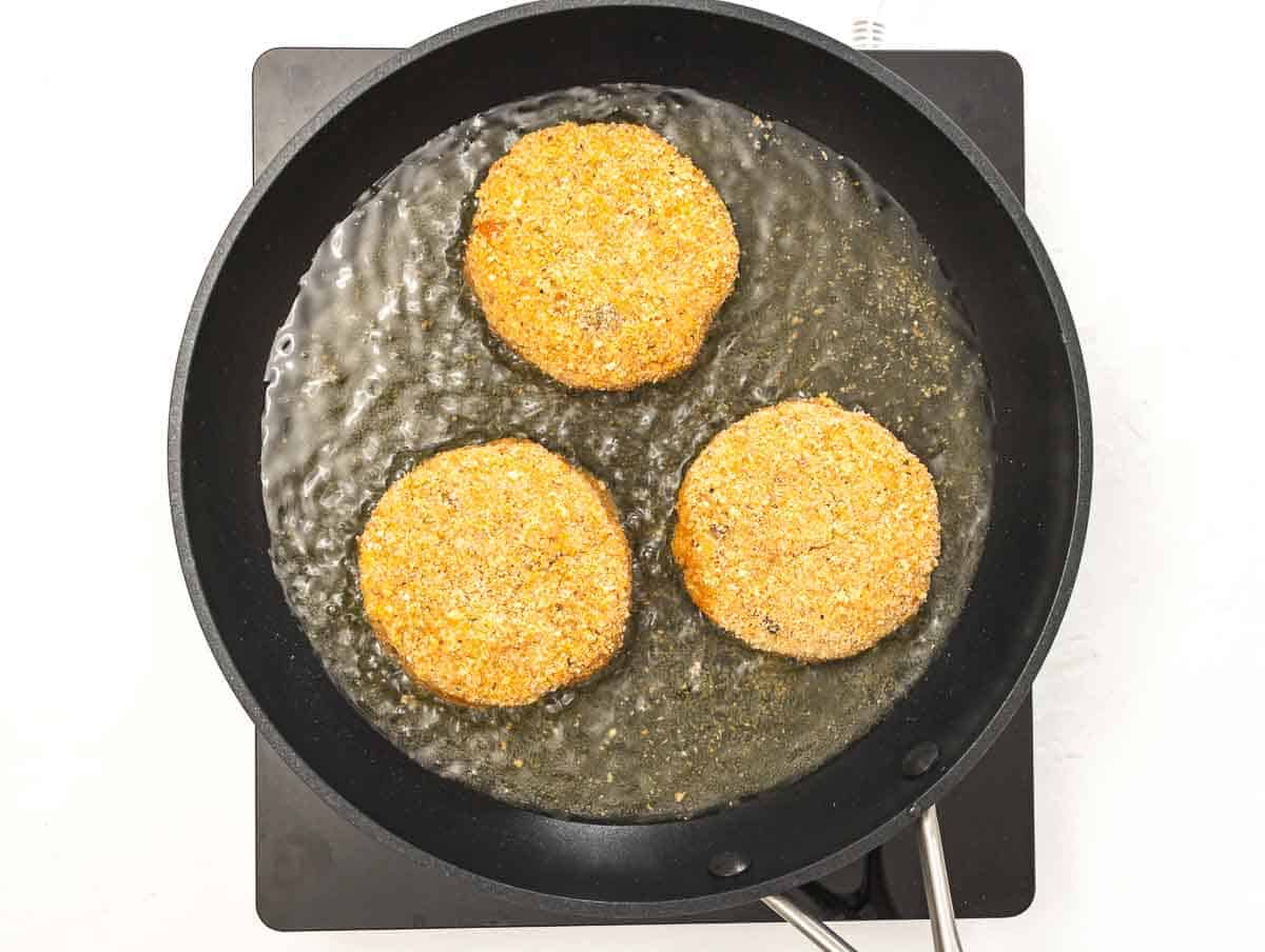 shallow frying risotto cakes in a large pan