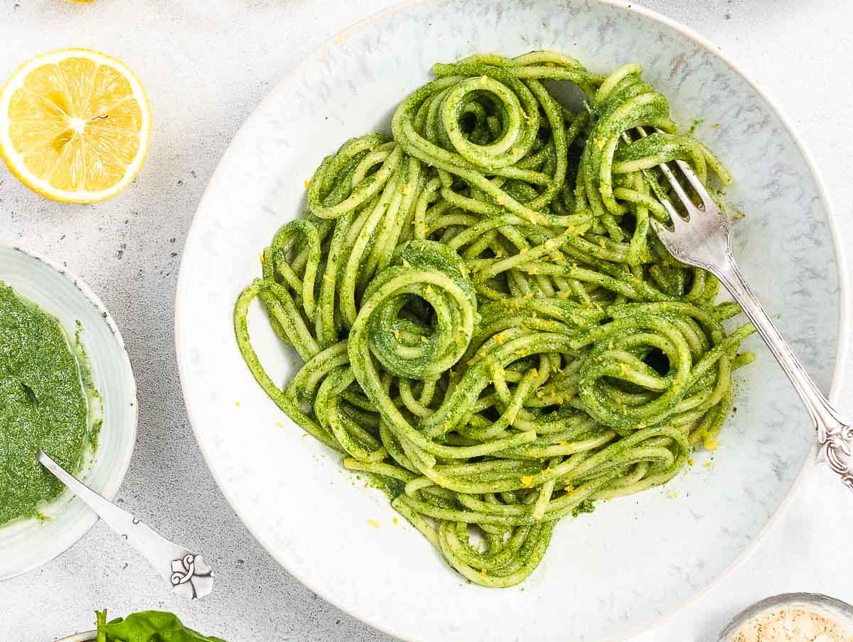 Spaghetti covered in green spinach pesto
