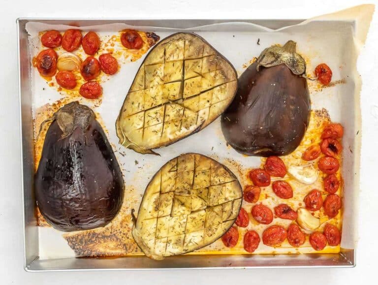 Step 1 – Roasting eggplant tomatoes and garlic on parchment-lined baking tray until golden and soft.