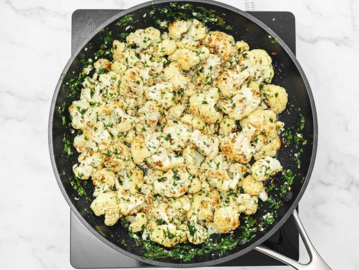 Step 3 Adding roasted cauliflower to garlic olive oil sauce in skillet.