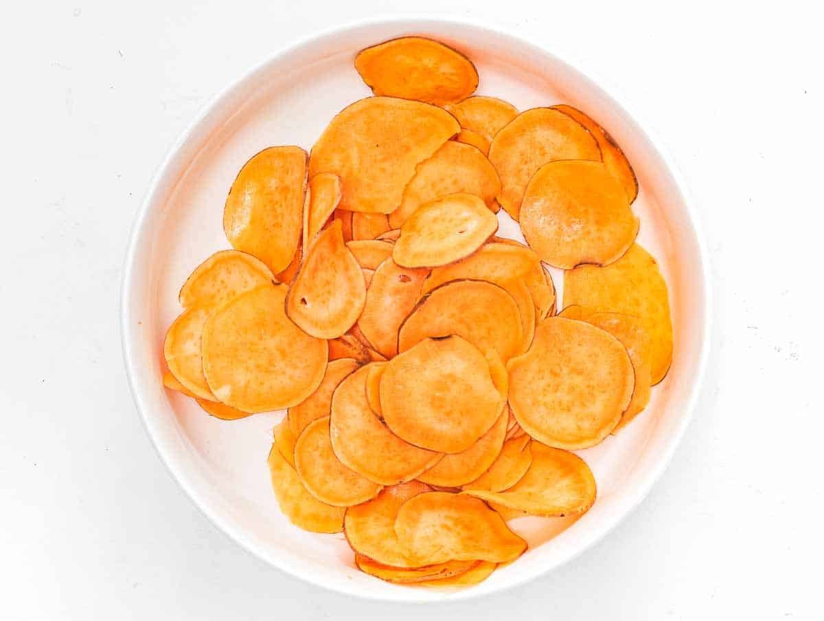 tossing sweet potato slices with olive oil and salt