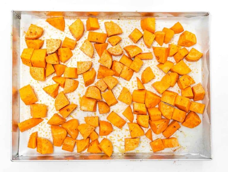 sweet potato dice on a baking sheet with olive oil, salt, and pepper