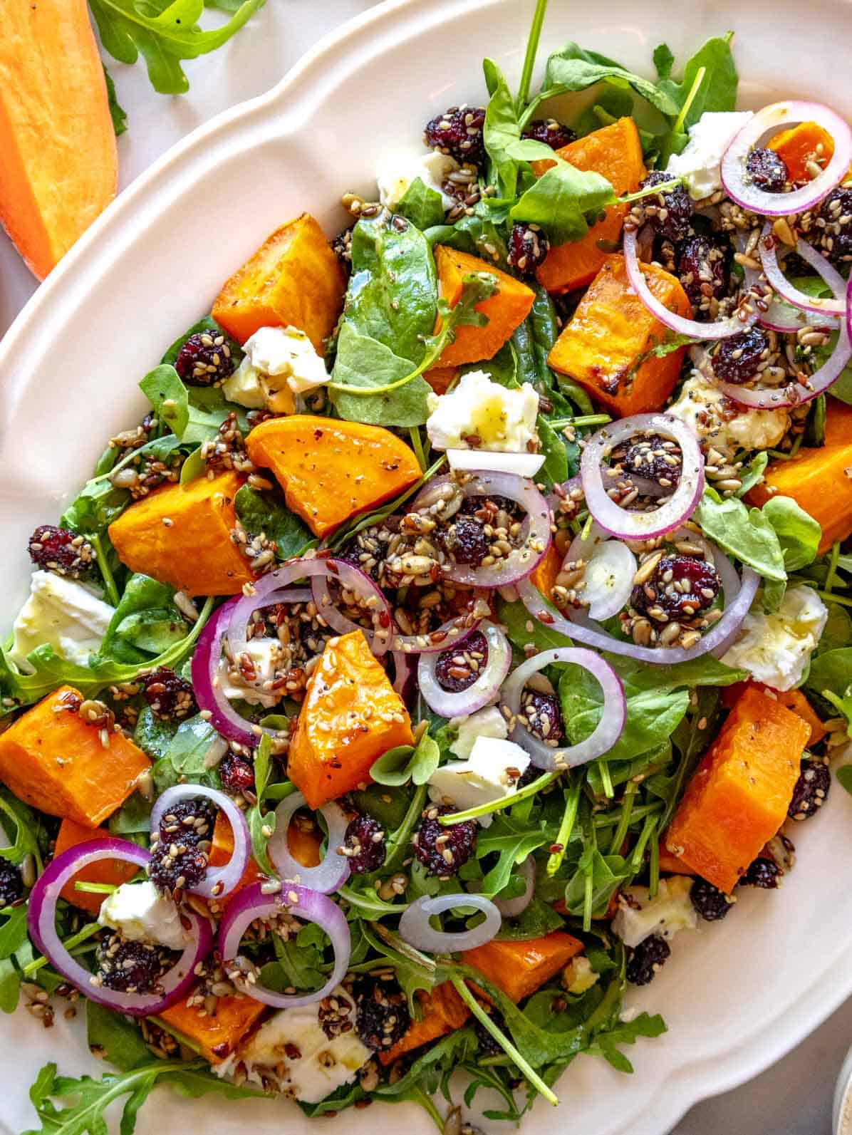 Sweet potato salad with red onion, arugula, feta, and seeds