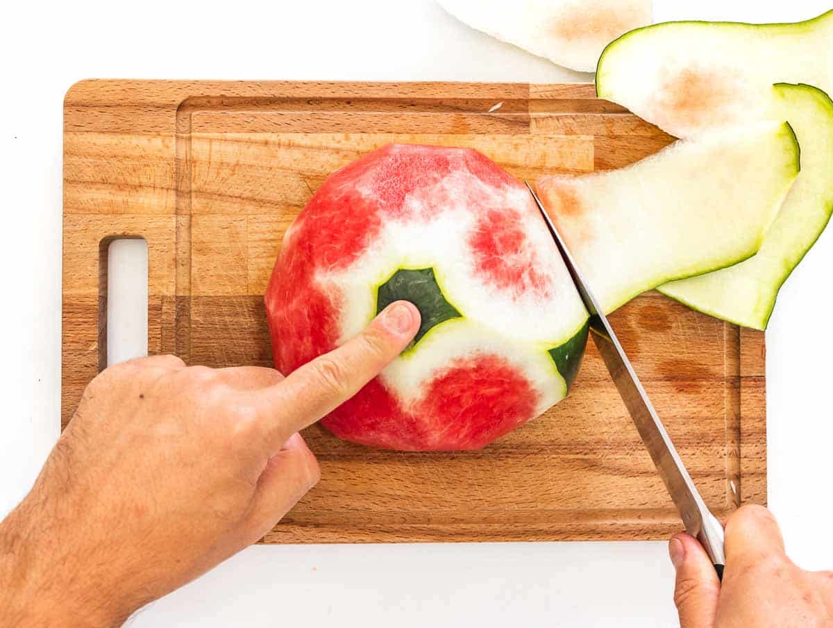 peeling the watermelon with a knife