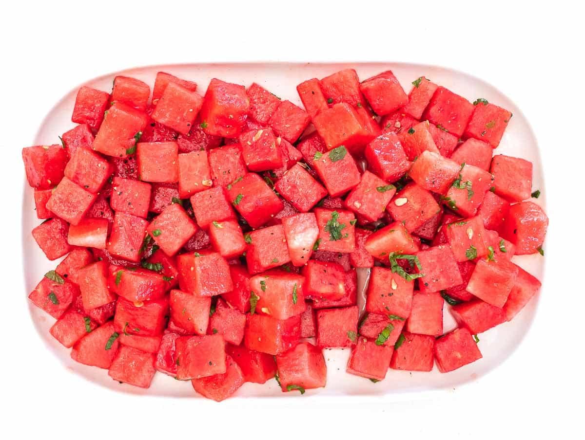 watermelon on serving platter with mint and condiments
